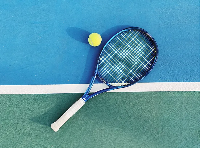 테니스 코트 위에 라켓과 테니스공이 놓여져 있는 모습 